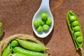 green peas beans and white spoon,young green peas in bowl and Pods peas on a grey old wooden background Royalty Free Stock Photo