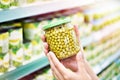 Green peas in jar in hands at shop Royalty Free Stock Photo