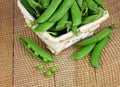 Green peas open pods on wooden background. . Close-up. Royalty Free Stock Photo