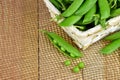 Green peas open pods on wooden background. . Close-up.