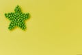 Green peas in the shape of a star on a yellow background Royalty Free Stock Photo
