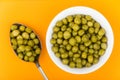 Green peas in small glass bowl and spoon Royalty Free Stock Photo