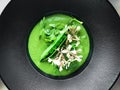 Green peas soup with roquette flowers Royalty Free Stock Photo