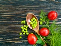 Green peas, spoon, tomato product on wooden background eating