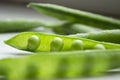 Green peas on the table. On a white background is an open pod of green peas. Green pea pods with young beans. Royalty Free Stock Photo