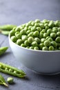 Green peas in white bowl with fresh pods. Fresh sweet pea pods.