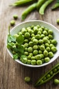 Green peas in white bowl with fresh pods Royalty Free Stock Photo