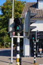 Green pedestrian light with a walking or waiting happy girl with ponytail at crossroads in the Netherlands. The name of