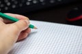 Green pencil in hand and a sheet of paper Royalty Free Stock Photo