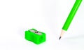 Green pencil with green pencil sharpener on white background. Stationery. Office tool. Back to school. Space for text. Education. Royalty Free Stock Photo