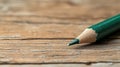 Green pencil tip on aged wood texture surface, a tool for ideas and expression. Royalty Free Stock Photo