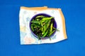 Green Pepper in a bowl on blue background Royalty Free Stock Photo