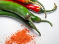 The green pepper and ground red pepper are isolated. Sharp pepper on a white background. Ingredient for a burning dish Royalty Free Stock Photo