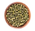 Green peppercorns in wooden bowl, isolated on white background. Organic spice. Dry green pepper grain. Top view. Royalty Free Stock Photo