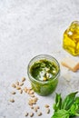 Green Pesto Sauce with Ingredients, Fresh Basil, Pine Nuts, Garlic and Cheese on light marbre background, space for text,