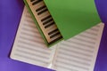 Green piano lies on top of an open music notebook on a blue background Royalty Free Stock Photo