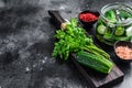 Green pickle cucumbers in a glass jar. Natural product. Black background. Top view. Copy space