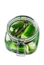 Green pickle cucumbers in a glass jar. Natural product. Isolated on white background. Top view.