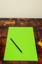 A green piece of paper with a pencil on it Royalty Free Stock Photo