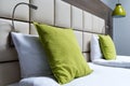 Green pillow, reading lamps and leather bed headboard in modern Royalty Free Stock Photo