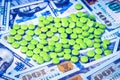 Green pills on the background of one hundred dollar bills. The concept of the expensive cost of healthcare Royalty Free Stock Photo