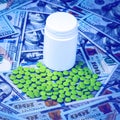 Green pills on the background of one hundred dollar bills. The concept of the expensive cost of healthcare or financing medicine. Royalty Free Stock Photo