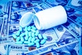 Green pills on the background of one hundred dollar bills. The concept of the expensive cost of healthcare or financing medicine. Royalty Free Stock Photo