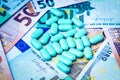 Green pills on the background of one hundred dollar bills. The concept of the expensive cost of healthcare