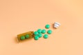 Green pills in the brown glass bottle on a orange background Royalty Free Stock Photo