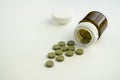 Green pills group are on the table. Brown plastic jar is near pills.  Closeup Royalty Free Stock Photo