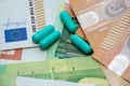 Green pills lie on pile of euro bills background Royalty Free Stock Photo