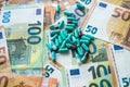 Green pills lie on pile of euro bills background Royalty Free Stock Photo