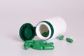 Green pills with pill bottle on white background with space for text Royalty Free Stock Photo