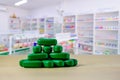 Green pills on wooden table with blurred pharmacy Royalty Free Stock Photo
