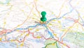 A green pin stuck in Nimes on a map of France