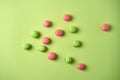 Green and pink mini macarons on light green background