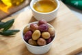 Green and pink olives in bow on wooden board Royalty Free Stock Photo