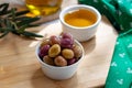 Green and pink olives in bow on wooden board Royalty Free Stock Photo