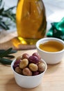 Green and pink olives in bow on wooden board Royalty Free Stock Photo