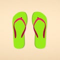 Green with pink striped flip flops on beach sand