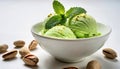 green pistachio nut ice cream, round scoops with a sprig of mint leaf leaves garnish in small plain white bowl with pistachios Royalty Free Stock Photo