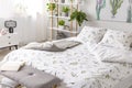 Green plant pattern on white bedding and pillows on a bed in a nature loving bedroom interior Royalty Free Stock Photo