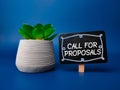 Green plant and wooden sign board with the word CALL FOR PROPOSALS