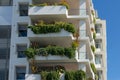 Green plants growing on the balconies of white building Royalty Free Stock Photo