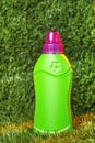 green plastic bottle of detergent on green nature background. summer concept