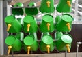 Green plastic buckets with nipples for feeding of calfs. Dairy farm