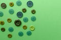 Green plastic buttons on green paper background