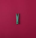 Green plastic clothes pin on a red background Royalty Free Stock Photo