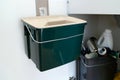 Green Plastic container for food waste/scraps. Trash cabinet inside a kitchen. Recycling/Composting Royalty Free Stock Photo