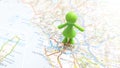 A green plastic figure standing on Rome on a map of Italy